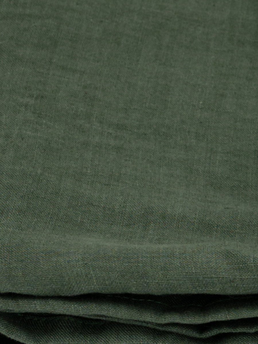 Close-up of folded forest green linen fabric with visible texture and weave